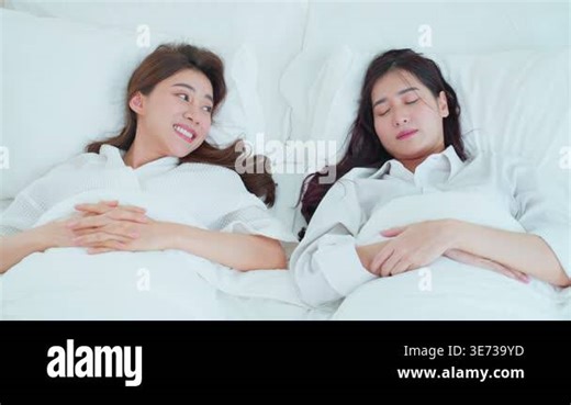 Two women lying together in bed