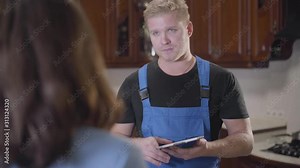 Back view of young brunette woman talking with repairman at home. Unrecognizable female house owner discussing household problems with worker. Service, housekeeping, professional occupation. Stock Video