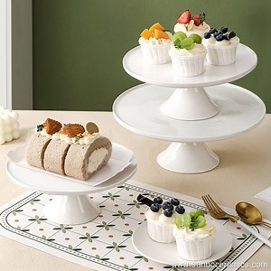 The white ceramic cake rack ceramic circular dessert display tray has...