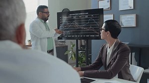 「オフィスでのチームミーティング中にプレゼンテーションを行いながら、画面上のグラフを女性のクリニカルディレクターや男性の同僚に説明する多人種医療の専門家」の動画素材（ロイヤリティフリー）3671931347 | Shutterstock