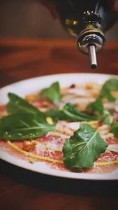 Carpaccio di Manzo: Carpaccio de carne, champignon fresco, alcaparras, croutons, nozes, molho mostarda, rúcula e parmesão ralado | Maremonti