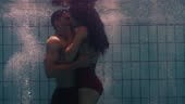Underwater couple kissing in swimming pool young people in love...