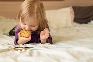 Beautiful Little Girl is Lying in Bed at Home Eating Cookies and Using a Mobile Phone, Taking Selfies, Watching Cartoons Stock Photo - Image of lying, communication: 238861092