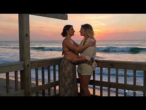 Lesbian kiss between two women at sunset on a beach part 2