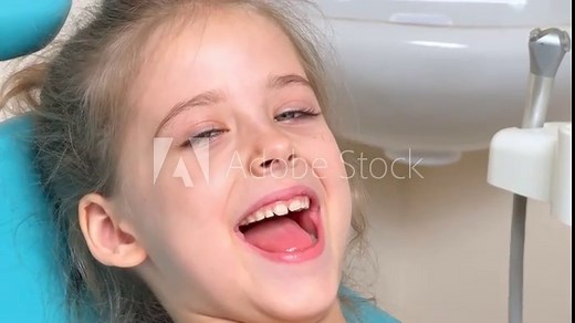 Close-up of little girl opening her mouth wide to the doctor to show her throat. Child is sitting with wide open mouth, with a tongue stuck out, clear view on the uvula and the soft palate