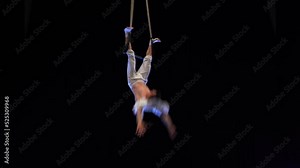 Muscular male air circus artist performances with dance trapeze