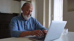 Focused Mature Older Business Man Typing on Computer Working From Remote Home Office Serious Bearded