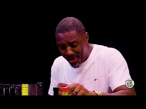 reaction meme: idris elba coughs and tears up over spicy hot wings on hot ones