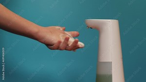 a child soaps his hands with liquid soap using a touch-sensitive soap dispenser. hand hygiene in children. child washes hands with liquid soap