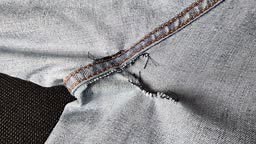 Hand-sewn holes on jeans, seams from sewing on the inside of denim