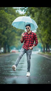 promt: A young Indian man standing on a wet street during light rain, holding a transparent umbrella with his right hand. He is wearing a red checked shirt with sleeves rolled up, grey slim-fit jeans, and white chunky sneakers. His head is slightly tilted down, smiling subtly. His left hand is in his pocket, and his right leg is lifted forward in a playful kicking pose. The street is shiny from the rain, with a blurred background of green trees# | Ismail Hosen