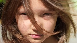 A 9-10 year old girl, or a teenager, stands on the street with her hair flying, Bullying concept, teenagers with mental health problems, resentment, stress, misunderstanding, puberty