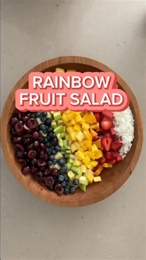 Rainbow Fruit Salad with a hot honey dressing, shaved, coconut, watermelon, strawberries, kiwi, apples, mangoes, oranges, cherries and blueberries #pride #fruitsalad #hothoney | The Salad Lab