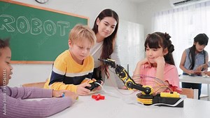 Smart primary students grouping to learning robot free electives with female teacher in classroom. Teacher female teach children assemble robot in science subject at elementary school.