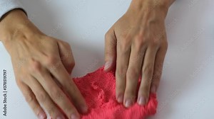 Hands crushing, squizing and crumpling pink plasticine, gum for hands with small balls inside, anti stress and relaxing game, close up
