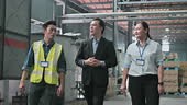 Asian factory management having discussion at warehouse, foreperson...