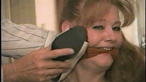 41 Yr OLD RED HEADED FAMOUS FASHION MODEL IS WRAP TAPE GAGGED, HEEL SMELLING, GAG TALKING, TOE-TIED, HANDGAGGED, MOUTH STUFFED, CLEAVE GAGGED AND STRUGGLING WHILE TIED TO A CHAIR | Clips4sale
