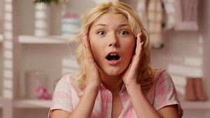 Happy excited smiling shocked surprised wonder amazed Caucasian woman girl female portrait face shock good news say wow holding head face open mouth big eyes in glamour pink candy bathroom at home