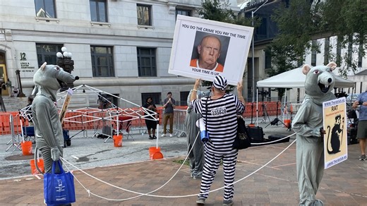 Protesters against Trump gather at Fulton County courthouse ahead of his planned surrender