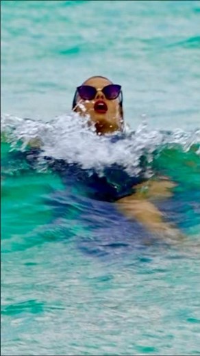 Supermodel in fancy dress enjoying the Haulover Inlet beach waves during a professional photoshoot.