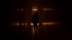 Silhouette Woman Walks Along a Dark Corridor Orange Light