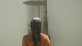 Young woman taking a tropical shower. Female showering in tropical...