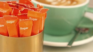 Download Enjoying coffee with sugar packets at a cozy cafe for free