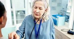 Doctor, woman and listening with stethoscope to patient heartbeat, healthcare consultation