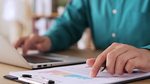 Businessman analyzing financial balance sheet and corporate profit report graph at office, calculating long term investment financial data, economic concept. stock market research and banking.