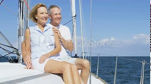 Mature American husband and wife outdoors on their sailing boat enjoying their vacation and retirement living