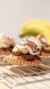 Want to try a recipe that you'll go absolutely bananas for? 🍌😍 Then give our delicious banana tarts a try. Here's how to get started. 👇 Ingredients: ✅ 1.5 kg Jus-Rol™ shortcrust pastry ✅ 75 g instant custard powder ✅ 10 g cocoa powder ✅ 350 ml boiling water ✅ 5 medium bananas ✅ 1 sachet Dream/Cream Topping ✅ 150 ml milk ✅ Cocoa powder, to dust Method: 1️⃣ Preheat oven to 190°C (170°C for fan assisted)/375°F/Gas Mark 5. 2️⃣Halve the pastry, roll it out to a thickness of 3mm and rest for 5 minu