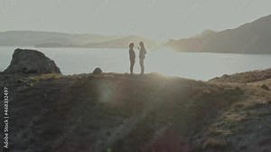 Personal yoga coach. Lesson during sunset on the coast. Perfect relaxation engaging in training. Two women enjoy gymnastics in pure nature.