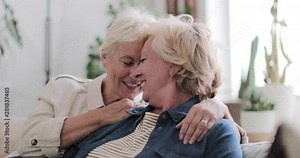 Mature lesbian couple at home on sofa