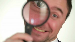 Download Male looking through magnifying glass for free