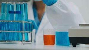 Download hand of scientist with test tube and flask in medical chemistry lab blue banner background for free