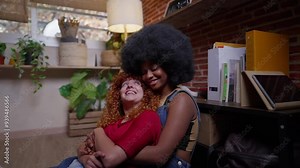 A multiracial lesbian couple, one with African American hair and the other with curly red hair, share a warm embrace in a cozy indoor environment. Multiracial Lesbian Couple Embracing in a Cozy Indoor