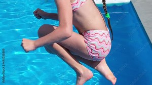 Happy fun loving girl jumping and diving into swimming pool at a pool party in summer sunny day. Slow motion. HD resolution video.