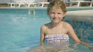 Little girl sitting in pool and smiling - Free Stock Video