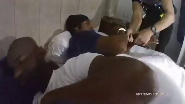 Moment police handcuff bleary-eyed drug dealers sleeping in bed