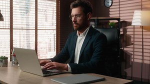 Serious concentrated working online internet job work Caucasian middle-aged business man adult businessman guy male employer entrepreneur in office typing laptop computer technology company at table