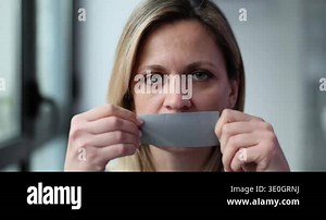 Young woman with mouth taped shut. Forbidden opinion and domestic violence concept Stock Video Footage - Alamy