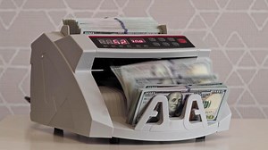 Currency counting machine in action with stacks of money