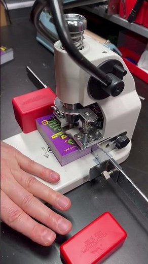 Punching holes for pin-back button display cards.