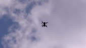 Silhouette of a Drone on a Background of Blue Sky with Clouds that...