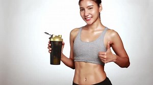 Slim perfect female body in sportswear drinking a whey protein supplement for fitness