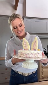 An eggstravagant Easter Bunny Ear cake by Sarah Butler. Happy Easter! #SuperValu Ingredients 360g self-raising flour 40g ground almonds 300g caster sugar Zest of 2 lemons 1 tsp baking powder 4 eggs, beaten 240ml milk 1 tsp vanilla extract 310g butter, melted To Decorate 150g butter, softened 300g icing sugar, sieved 1 tsp vanilla extract 4 tbsp fresh cream 250g lemon curd 150g sprinkles 100g white chocolate 100g mini eggs Method Preheat the oven to 180°C (160°C fan) or Gas Mark 4. Grease the cak