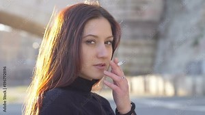 sensual brunette smoking cigarette staring at camera- slow motion-outdoor