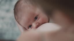 A shot of a newborn sucking a mother. Shot over the mother's...