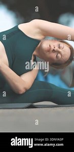 Adult athletic woman sitting in a splits and stretching to the sides on the outdoors sports ground. Mid shot Stock Video Footage - Alamy