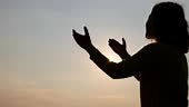 Silhouette of Human hands open palm up worship. Eucharist Therapy...